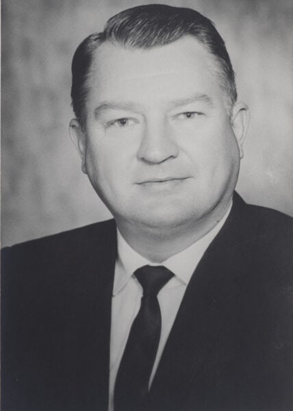 Black and white portrait of George Foster Jr, a man in a suit and tie with short hair, facing the camera. The image captures the essence of his leadership at Guaranty Broadcasting, reflecting his dedication to the community through initiatives like the Guaranty Foundation.